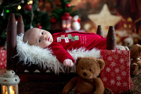 Retrato de bebê recém-nascido em roupas de Papai Noel em pequena cama de bebê — Fotografia de Stock