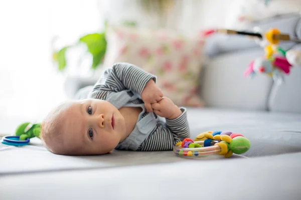 Søt liten gutt som leker med leker i en solrik stue – stockfoto