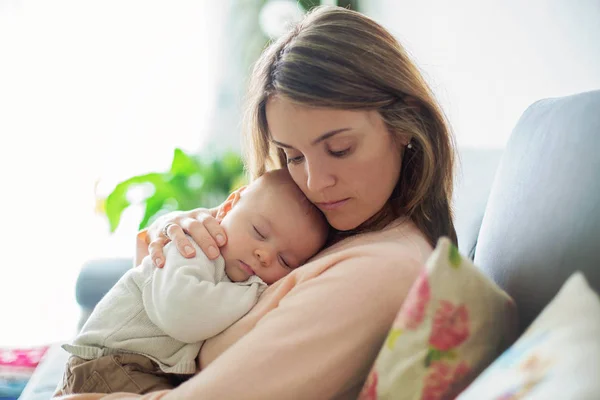 Jovem mãe, segurando ternamente seu bebê recém-nascido — Fotografia de Stock