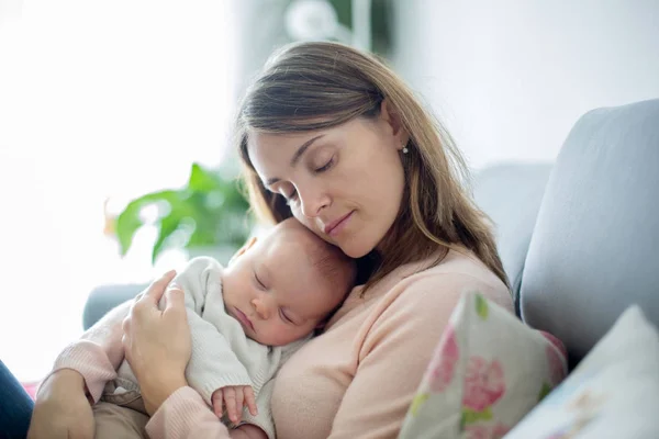 Joven madre, sosteniendo tiernamente a su bebé recién nacido — Foto de Stock