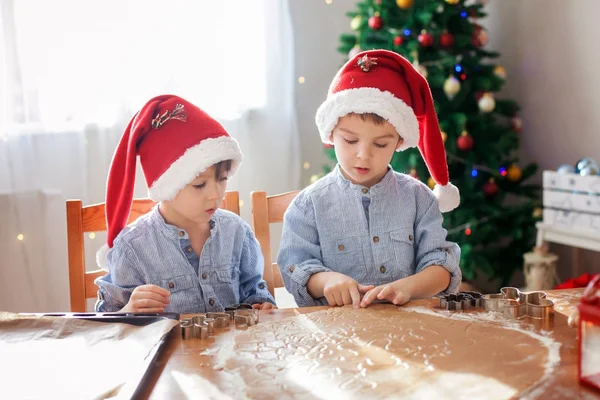 Δύο χαριτωμένα αγόρια με καπέλο santa, προετοιμάζοντας τα cookies στο σπίτι, χρι — Φωτογραφία Αρχείου