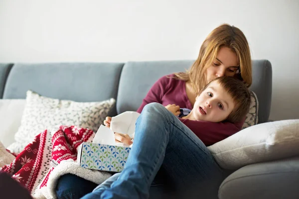 Junge Mutter hält ihren kleinen kranken Jungen — Stockfoto