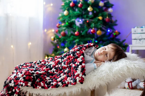 Kleine jongen, slapen onder de kerstboom — Stockfoto