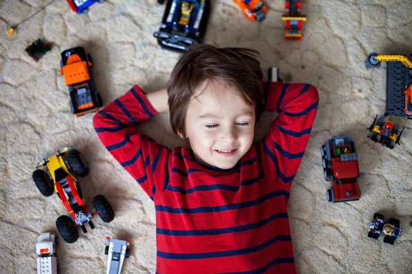 Criança brincando com muitos brinquedos de plástico coloridos interior — Fotografia de Stock