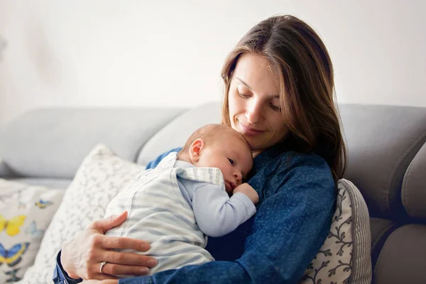 若い母親は、自宅に彼女の生まれたばかりの赤ちゃんの男の子にキス — ストック写真