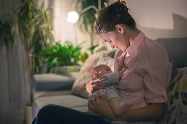 Jovem mãe bonita, amamentando seu bebê recém-nascido menino — Fotografia de Stock