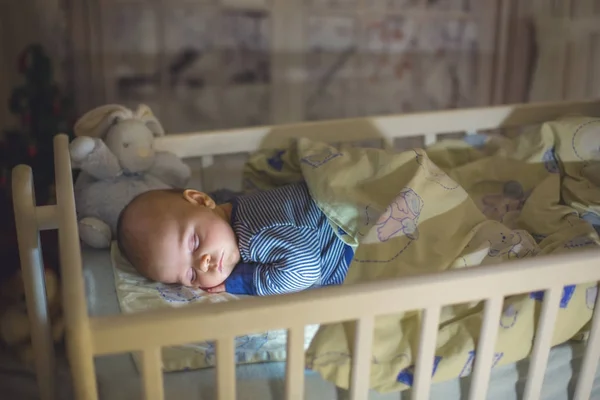 Adorable bebé recién nacido, durmiendo en la cuna por la noche — Foto de Stock