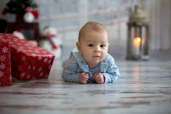 Niedliches Weihnachtsporträt eines kleinen Jungen, der auf seinem Bauch liegt o — Stockfoto