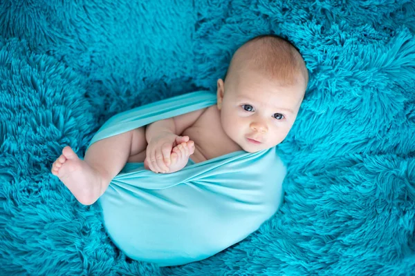 可爱的三月大的男婴在蓝色的包装, 躺在一个蓝色的血乳酸 — 图库照片