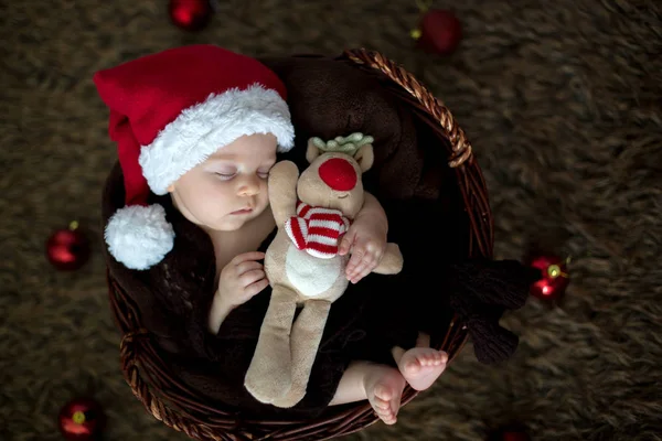 Niedliches drei Monate altes Baby mit Bärenhut in einem Korb, schlafend — Stockfoto