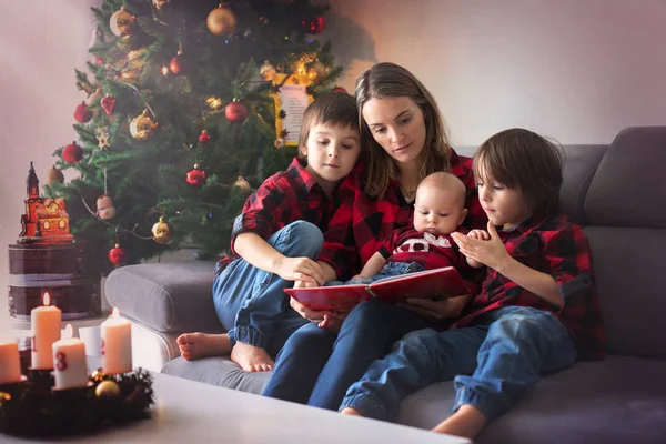Feliz retrato familiar en Navidad, madre, leyendo un libro para él — Foto de Stock