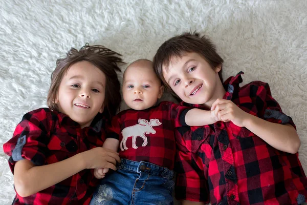 Flo üzerinde yalan üç mutlu çocuk, erkek kardeşler, portre — Stok fotoğraf