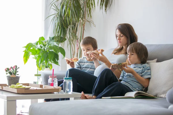 Glückliche junge Familie, schwangere Mutter und zwei Jungen, essen leckere p — Stockfoto