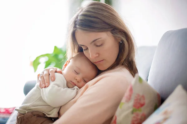 Jovem mãe, segurando ternamente seu bebê recém-nascido — Fotografia de Stock