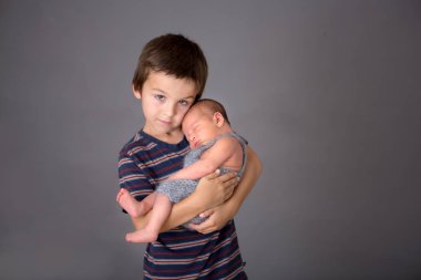 Güzel çocuk, hassasiyet ile sarılma ve onun yeni doğan Bebek Bakımı