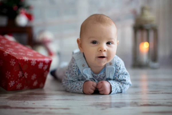Niedliches Weihnachtsporträt eines kleinen Jungen, der auf seinem Bauch liegt o — Stockfoto
