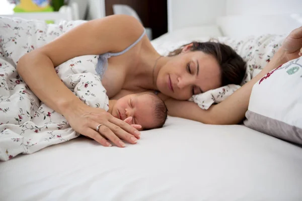 Jovem mãe dormindo com seu bebê, segurando-o — Fotografia de Stock