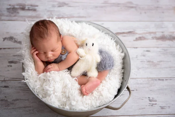 Pasgeboren babyjongen, rustig slapen in de mand, gekleed in knit — Stockfoto