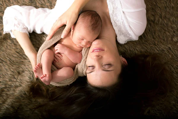 Красивая мать обнимается с нежностью и ухаживает за своим новорожденным — стоковое фото