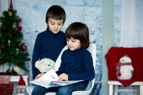 Bambini carini, ragazzi, leggendo un libro, seduti su una sedia — Foto Stock