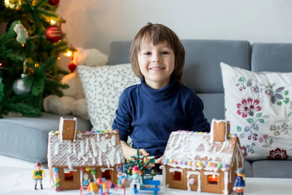 Мила дитина, хлопчик, грає з імбирними будиночками — стокове фото