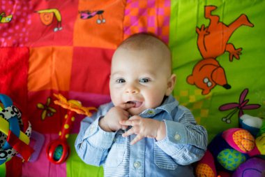 Mutlu üç aylık erkek bebek evde renkli üzerinde oynamak, bir