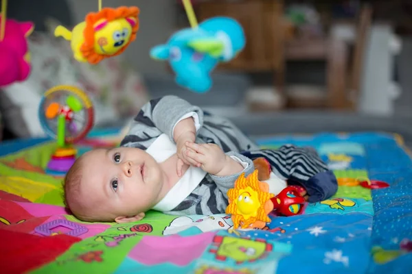 Happy three months old baby boy, playing at home on a colorful a — Stock Photo, Image