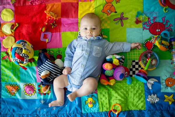 Happy three months old baby boy, playing at home on a colorful a — Stock Photo, Image