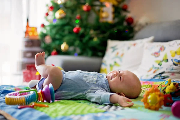 Three months old baby boy, crying at home on a colorful activity — Stock Photo, Image