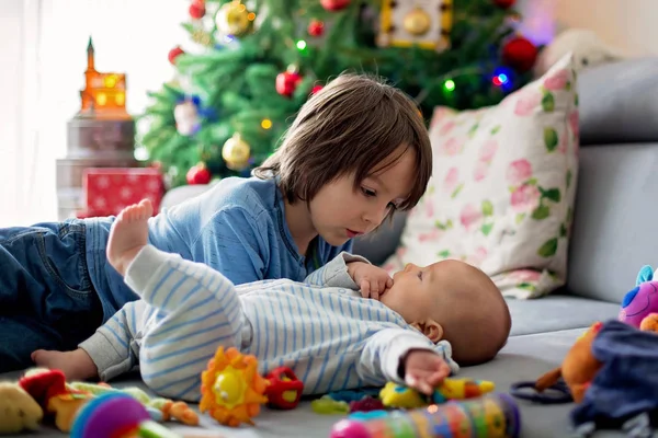 Six years old preschool boy, playing at home with his newborn ba — Stock Photo, Image