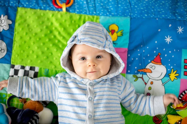 Feliz niño de tres meses de edad, jugando en casa en un colorido un — Foto de Stock