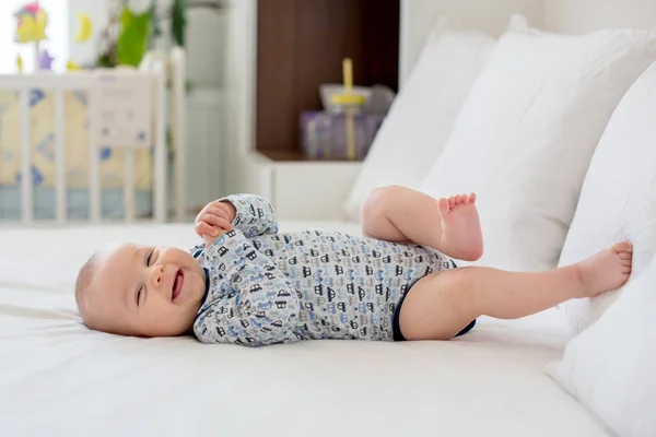 かわいい新生児男の子、朝ベッドで遊んで — ストック写真