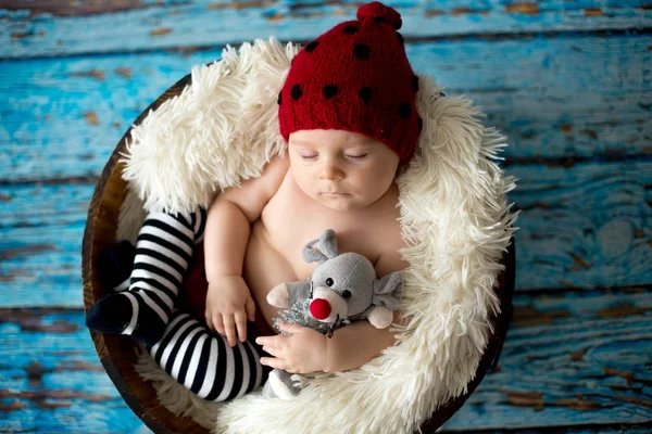 Little baby boy with knitted hat in a basket, happily smiling — Stock Photo, Image