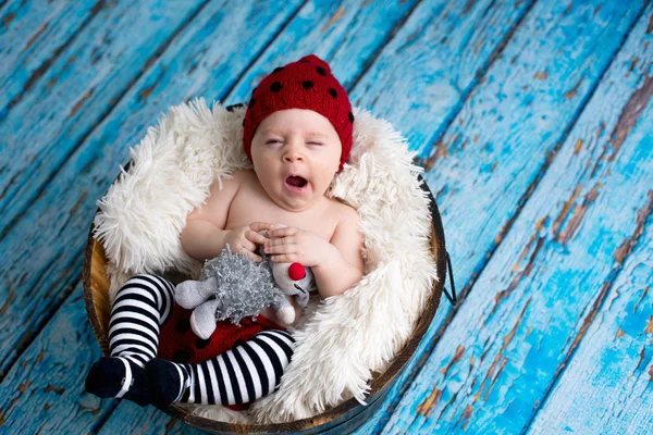 Little baby boy with knitted hat in a basket, happily smiling — Stock Photo, Image