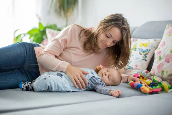 Bonito menino e sua mãe, deitado no sofá na sala de estar — Fotografia de Stock