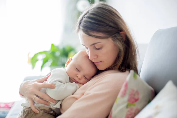 Joven madre, sosteniendo tiernamente a su bebé recién nacido —  Fotos de Stock
