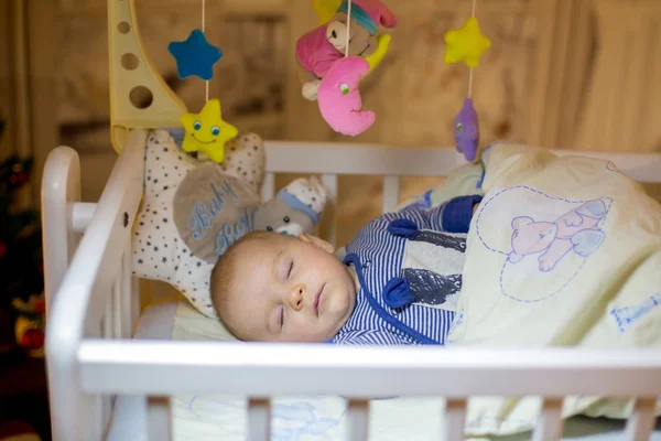 Entzückender neugeborener Junge, der nachts im Kinderbett schläft — Stockfoto