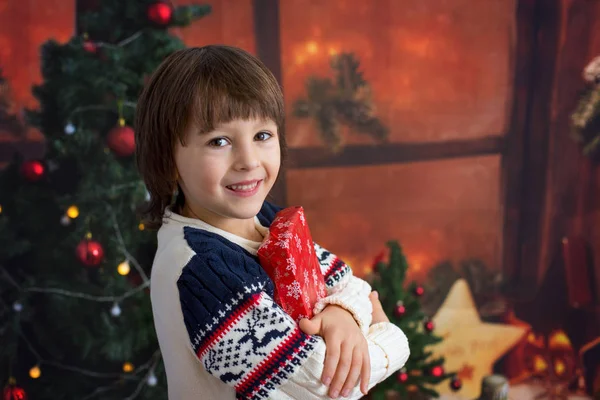 Χαριτωμένο αγόρι προσχολικής ηλικίας, κρατώντας το χριστουγεννιάτικο δώρο, τη χαρά και την ευτυχία — Φωτογραφία Αρχείου