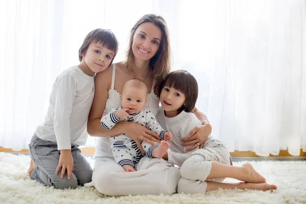 Семейный портрет матери и трех ее мальчиков, изолированных на белом — стоковое фото