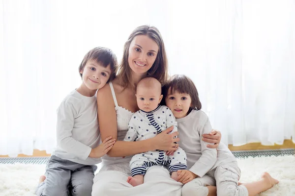 Ritratto di famiglia della madre e dei suoi tre figli, isolati su bianco — Foto Stock