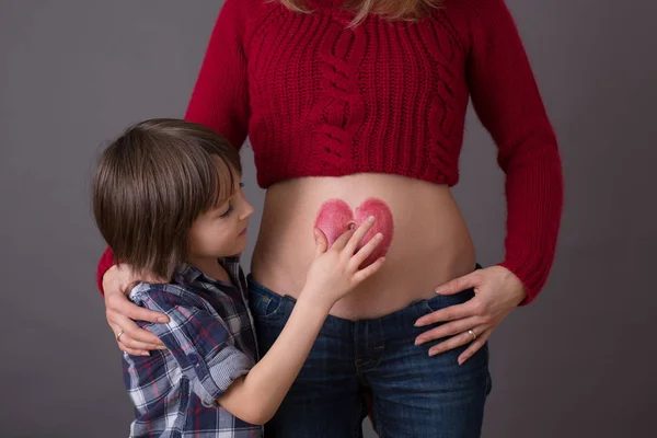 아름 다운 유치원 아이, 그의 임신 엄마 포옹 — 스톡 사진