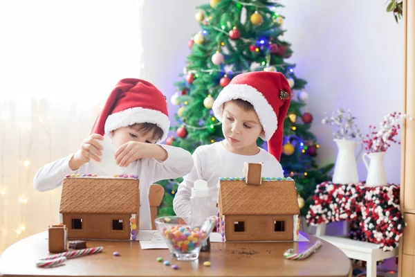 Two sweet boys, brothers, making gingerbread cookies house — Stock Photo, Image
