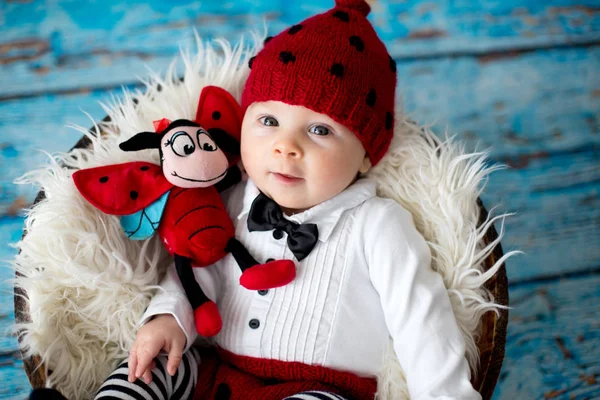 Malý chlapeček s pletená Beruška klobouk a kalhoty v košíku — Stock fotografie