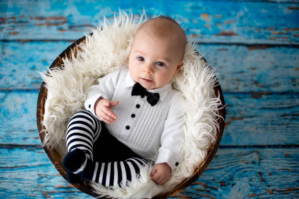 Menino com chapéu de joaninha de malha e calças em uma cesta — Fotografia de Stock