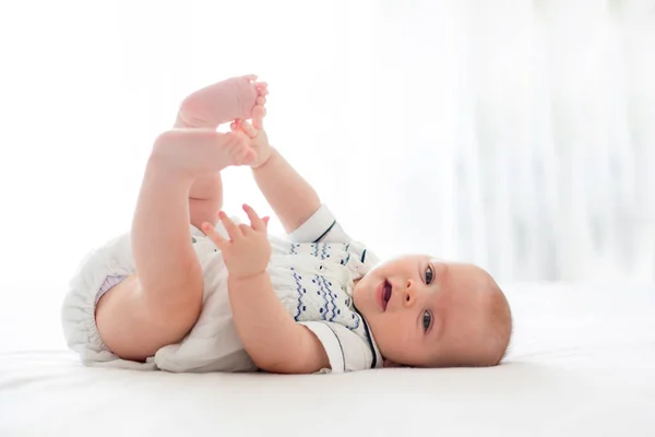 Lindo niño de cuatro meses, jugando en casa en la cama — Foto de Stock