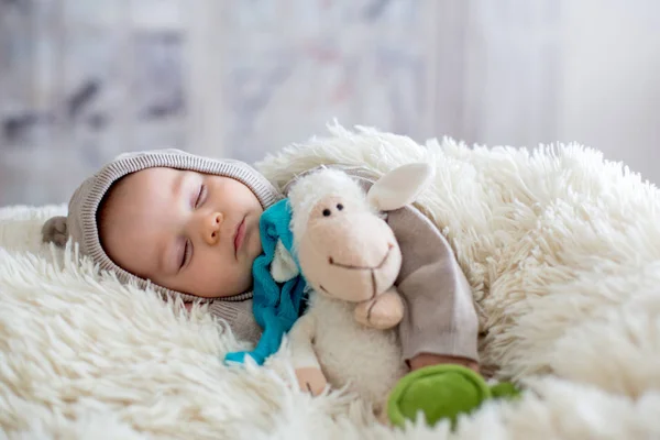 Dulce bebé en el oso en general, durmiendo en la cama con oso de peluche —  Fotos de Stock