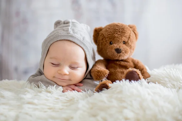 Sweet baby boy in bear overall, sleeping in bed with teddy bear — Stock Photo, Image