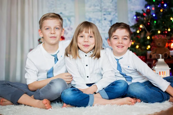 Tre børn, søskende, der har deres juleportræt - Stock-foto