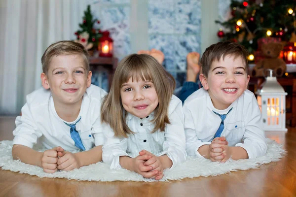 Tre børn, søskende, der har deres juleportræt - Stock-foto