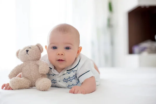 Cute little four month old baby boy, playing at home in bed — Stock Photo, Image